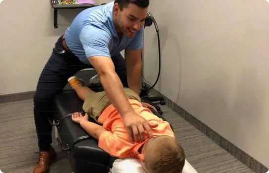 Chiropractors performing adjustments on children lying on chiropractic tables